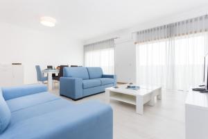 een woonkamer met blauwe banken en een tafel bij T3 Bliss by Seewest in Albardeira
