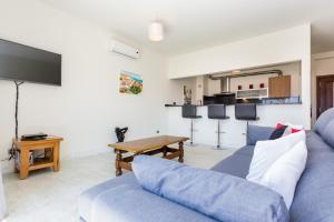 a living room with a blue couch and a table at Fabrica da Ribeira Apartment by Seewest in Lagos