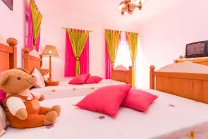 ein Teddybär sitzt auf einem Bett in einem Schlafzimmer in der Unterkunft Sunflower Villa by Seewest in Porto de Mós + 22 Fotos