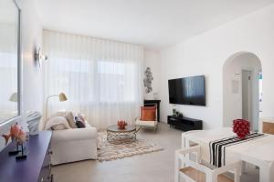 a white living room with a white couch and a tv at Villa LAVINIA MARE E PISCINA PRIVATA in Plaia Grande