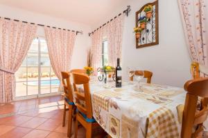ein Esszimmer mit Tisch und Stühlen und einem Fenster in der Unterkunft Sunflower Villa by Seewest in Porto de Mós