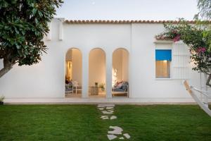 een wit huis met een gazon ervoor bij Villa LAVINIA MARE E PISCINA PRIVATA in Plaia Grande