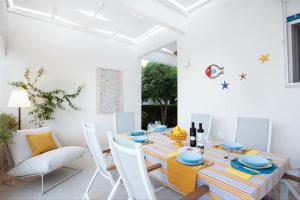 Villa LAVINIA MARE E PISCINA PRIVATA في Plaia Grande: غرفة طعام بيضاء مع طاولة وكراسي