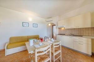 a kitchen and dining room with a table and a couch at Residenza Le Farfalle in Tergu