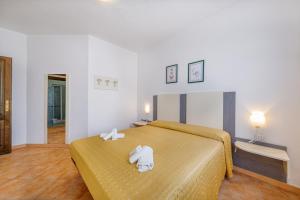 1 dormitorio con 1 cama con 2 toallas en Residenza Le Farfalle, en Tergu