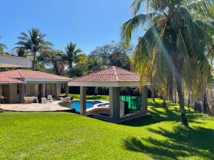 um quintal com um gazebo e uma piscina em Beach On The Rocks em El Zonte