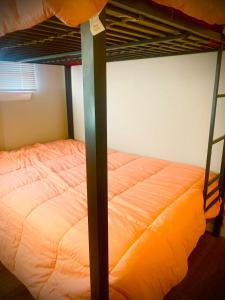 a bedroom with two bunk beds with an orange mattress at The Doze Off in Houston