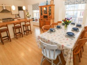 a kitchen with a dining room table with chairs and a tablecloth at Gower View in Tenby