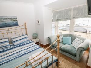 a bedroom with a bed and a couch and a window at Gower View in Tenby