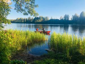 two people in a boat on a lake at Tiny hut in the forest overlooking the river in Avesta