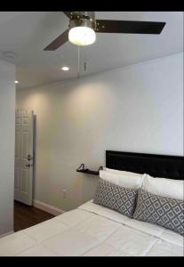 費城的住宿－Private Luxe Room A Hidden Gem With Private Bath & Kitchen，卧室配有白色的床和吊扇