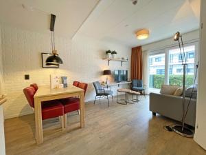 a kitchen and living room with a table and chairs at Appartementen Bos en Duin Texel in Den Hoorn