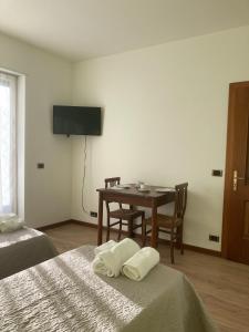 um quarto com duas camas e uma mesa e uma televisão em Lavini em Marco