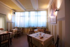 un comedor con mesas y sillas y una ventana en Affittacamere Dal Falco, en Pienza