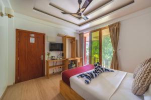 a bedroom with a bed with a ceiling fan at Ocean Lilly Inn in Hangnaameedhoo