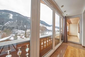 a room with a large window with a mountain view at Marys Holiday Penthouse in Saalbach-Hinterglemm