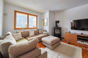 a living room with a couch and a flat screen tv at Marys Holiday Penthouse in Saalbach-Hinterglemm