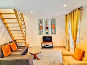 Una sala de estar con un sofá y un televisor. en Stableyard cottages, en Lamorlaye