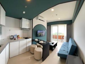 uma cozinha e sala de estar com uma mesa e um sofá em REOTEL at Kaina Tower - The Nove em Telukmataikan