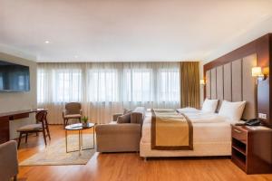 um quarto de hotel com uma cama e um sofá em Palast Hotel em Hürth