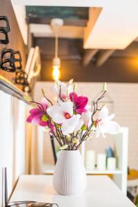 a white vase filled with flowers on a table at Center underground studio in Bratislava