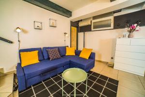 uma sala de estar com um sofá azul e almofadas amarelas em Center underground studio em Bratislava