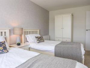 two beds sitting next to each other in a bedroom at Bryntirion in Moelfre