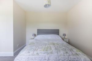 Schlafzimmer mit einem Bett mit weißen Wänden in der Unterkunft Blacklaines Annexe in Gloucester