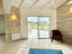 sala de estar con piscina y silla en Cabaña con spa Vida Abundante en Villa Yacanto