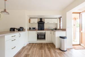 a kitchen with white cabinets and a stove at Blacklaines Annexe in Gloucester