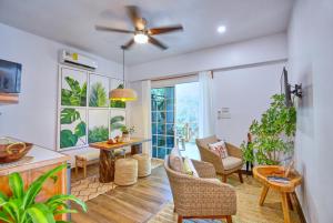 a living room with a ceiling fan and a table and chairs at Villa Massis Luxury Villas in San Ignacio