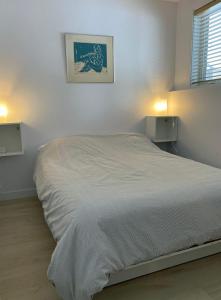 a white bedroom with a large bed in it at Condo En Quatre Temps in Beaupré
