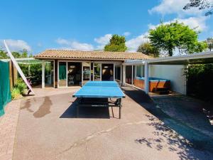 a blue ping pong table in the backyard of a house at Villa Patio + jacuzzi, FREE Surf+Body+Sup in Capbreton