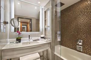 W łazience znajduje się umywalka, lustro i prysznic. w obiekcie Hyatt Regency London Albert Embankment w Londynie