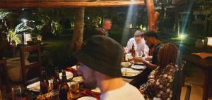 un grupo de personas sentadas en una mesa comiendo comida en Hotel Heladiv, en Anuradhapura