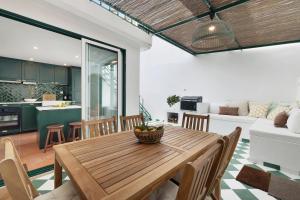 a kitchen and living room with a wooden table and chairs at Casa da Praia in Alcochete