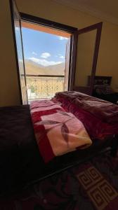 um quarto com uma cama e vista para uma janela em Gite Oukaimeden em Oukaïmeden