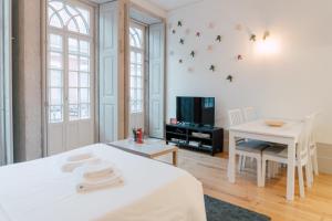Zimmer mit einem Bett, einem Tisch und einem TV in der Unterkunft Casa Burguesa Rua do Almada - Porto city center in Porto
