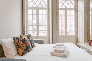 ein Schlafzimmer mit einem Bett mit Handtüchern darauf in der Unterkunft Casa Burguesa Rua do Almada - Porto city center in Porto