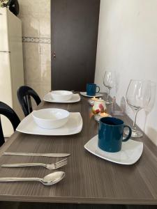 una mesa con platos y utensilios encima en Apartaestudio amoblado - Pasoancho/Sur-Centro/Cali, en Cali