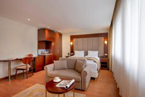una camera d'albergo con letto, divano e tavolo di Palast Hotel a Hürth