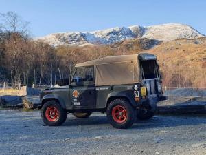 a green jeep parked on a gravel road at Herdwicks in Millom