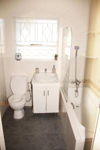 La salle de bains est pourvue de toilettes, d'un lavabo et d'une fenêtre. dans l'établissement Adorable Private Room in Germiston, à Germiston