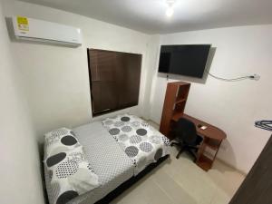 Dormitorio con cama, escritorio y TV en Apartaestudio amoblado - Pasoancho/Sur-Centro/Cali, en Cali