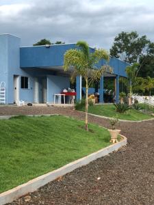 un edificio azul con una palmera delante de él en Chacara Beach Lazer, en Foz do Iguaçu