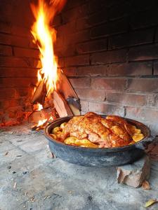 a chicken cooking in a pan in a brick oven at Vikendica Mimiena in Račić