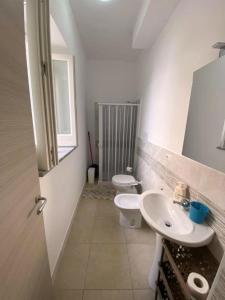 リーパリにあるAppartamenti Holiday Housing Lipari Centroの白いバスルーム(トイレ2つ、シンク付)