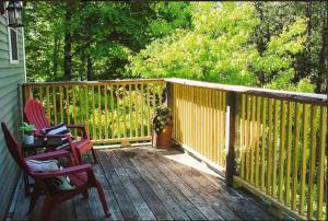 une terrasse en bois avec deux chaises et une clôture dans l'établissement Cozy Burke Home, 