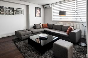 een woonkamer met een bank en een tafel bij 2 bedroom Penthouse in city center, free parking in Sarajevo