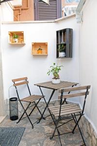 uma mesa e duas cadeiras sentadas ao lado de uma parede em B&Bea sweet home Aurelia em Roma